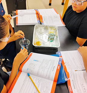 science students sitting at a table completing a color mixing lab